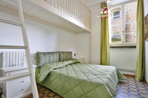 a bedroom with a green bed and a staircase at B&b Pergola House in Lucca