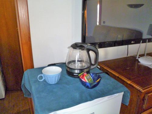 un bollitore per il tè e una tazza su un tavolo di La Mansarda di Pupillo a Francavilla Fontana