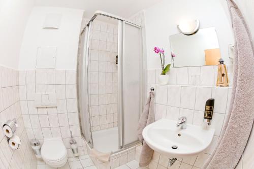 a white bathroom with a shower and a sink at Haus Svantekahs in Glowe