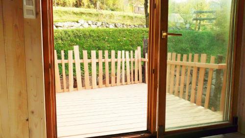 a door open to a porch with a wooden fence at La roulotte du bucheron in Lapoutroie