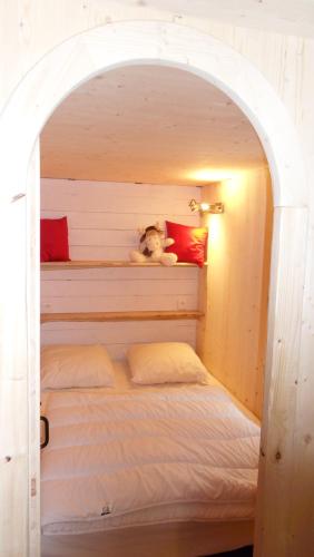 a bed with a teddy bear sitting on top of it at La roulotte du bucheron in Lapoutroie