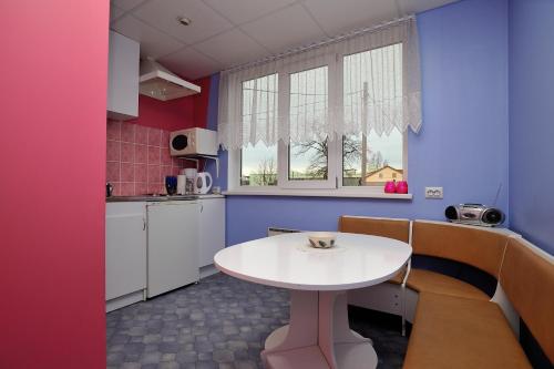una pequeña cocina con una mesa blanca en una habitación en Jaani Külaliskorter, en Pärnu