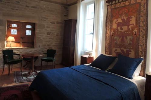 een slaapkamer met een bed en een tafel met stoelen bij Maison Romane 1136 in Cluny