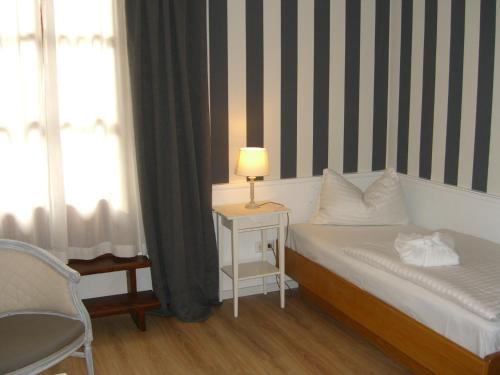 a bedroom with a bed with a lamp and a chair at Villa Bucher - Metnitztalerhof in Friesach