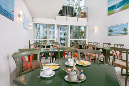 Haus Svantekahs في غلوفي: غرفة طعام مع طاولات وكراسي خضراء