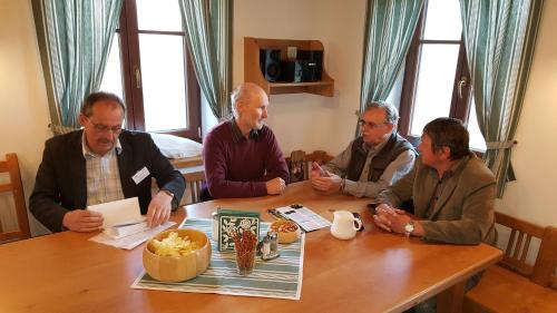 a group of men sitting around a wooden table at Pension Konírna in Huntířov