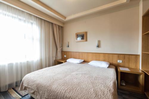 a hotel room with a bed and a window at Hotel Lirak in Tetovo
