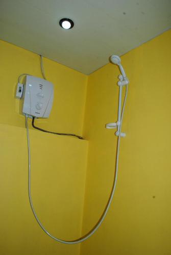 a yellow wall with a shower in a room at Park-Hotel Khoren's Lake in Areni