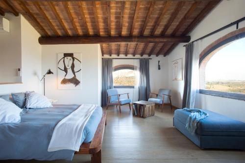 a bedroom with a bed and a chair and a window at Quercia Al Poggio in Barberino di Val dʼElsa