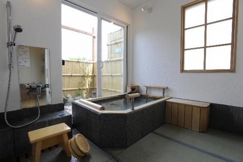 Habitación con baño con bañera. en Tenshino Iruka, en Ito