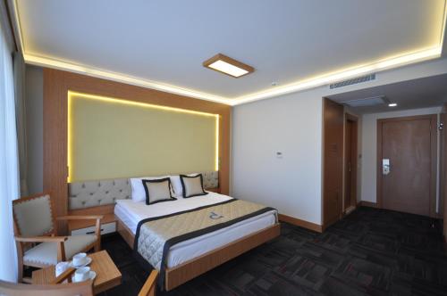 a hotel room with a bed and a chair at Double Comfort Hotel in Ankara