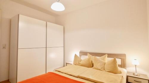 ein Schlafzimmer mit einem orangenen Bett und einem weißen Schrank in der Unterkunft Villa Vineta Whg. 207 in Ahlbeck