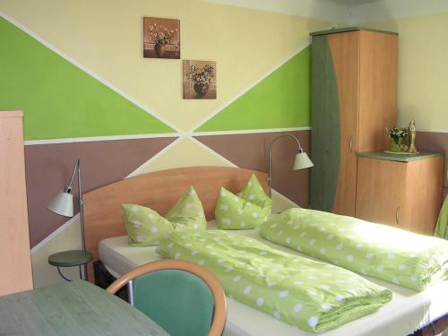 a bedroom with two beds with pillows and a table at Hotel Sternen in Lenzkirch