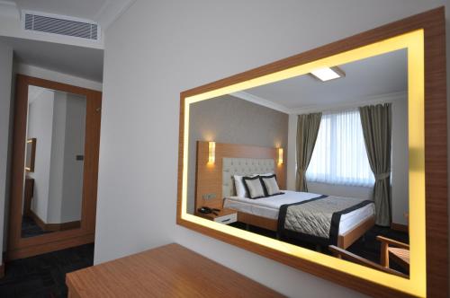 a mirror in a hotel room with a bed at Double Comfort Hotel in Ankara