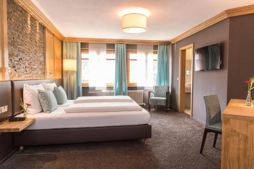 a hotel room with two beds and a television at Hotel & Restaurant Becher in Donzdorf