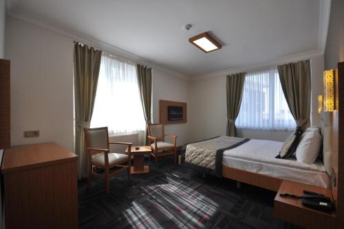 a hotel room with a bed and a table and chairs at Double Comfort Hotel in Ankara