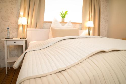 1 cama blanca en un dormitorio con ventana en Weddeler Hof, en Cremlingen