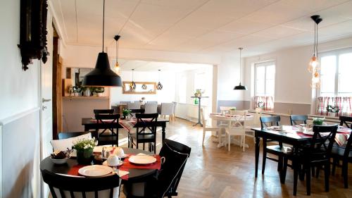 a dining room with tables and chairs and a kitchen at Weddeler Hof in Cremlingen