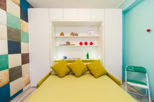 Cette petite chambre comprend un lit jaune avec des oreillers jaunes. dans l'établissement Casa Vacanza al Castello, à Barletta