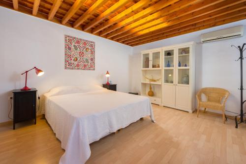 リンドスにあるVilla Lindosの白いベッドと木製の天井が備わるベッドルーム1室が備わります。