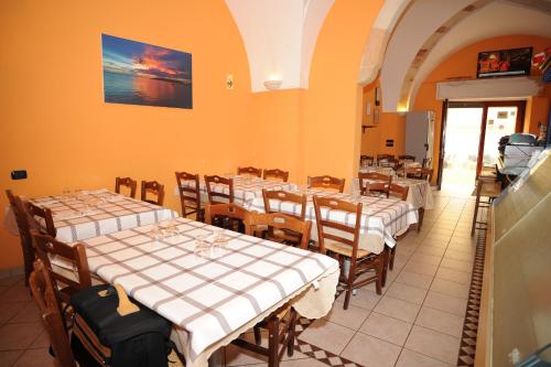 a restaurant with tables and chairs with white tablecloths at Hotel Miramare in Porto Cesareo