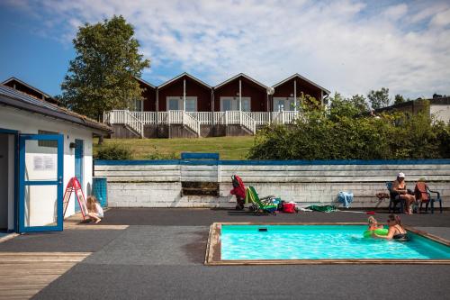 a group of people playing in a swimming pool at Allégården Kastlösa Stugor in Mörbylånga