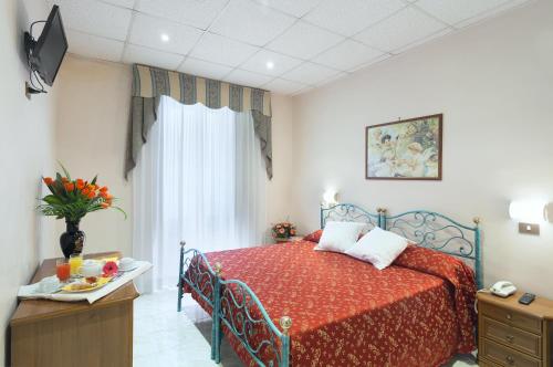 - une chambre avec un lit doté d'un couvre-lit rouge et d'une fenêtre dans l'établissement Hotel Oriente, à Rome
