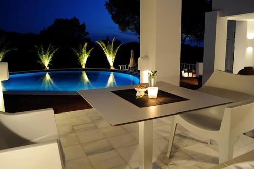 a table and chairs with a view of a pool at Hotel Village in Cala Vadella