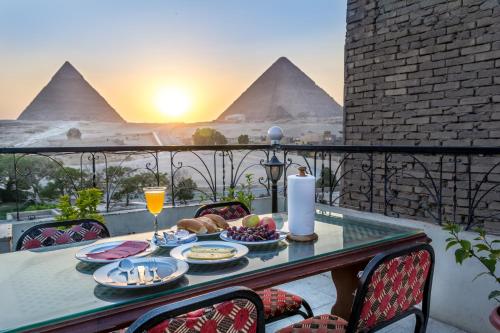 a table with food and a view of the pyramids at Pyramids View Inn in Cairo