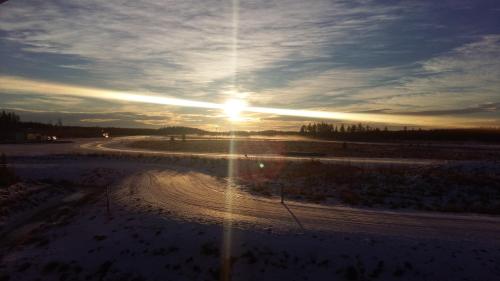 a road with the sun setting in the sky at Villa APR in Kurikka