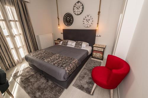 a bedroom with a bed and a red chair at Filoxenia Hotel & Spa in Kalavrita