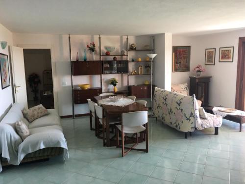 Porto San Paolo Sea Villa في بورتو سان باولو: غرفة معيشة مع طاولة وأريكة