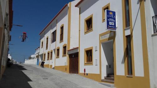 a building with a sign on the side of a street at Sol da Vila in Vila Nova de Milfontes