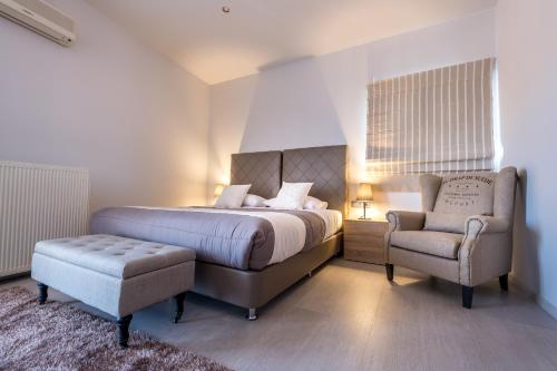 a bedroom with a bed and a chair at Filoxenia Hotel & Spa in Kalavrita