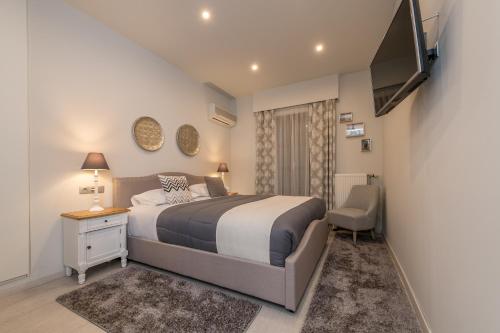 a bedroom with a bed and a television in it at Filoxenia Hotel & Spa in Kalavrita