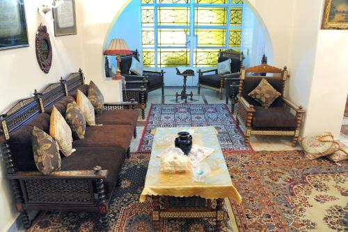 a living room with couches and a table at Grand Museum Guest House in Kafr Abū ʼumaydah