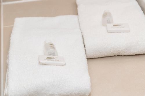 ein Badezimmer mit weißen Handtüchern auf einer Badewanne in der Unterkunft Gästehaus Becher in Donzdorf