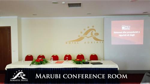 a meeting room with a table with red chairs at Adriatik Hotel, BW Premier Collection in Durrës