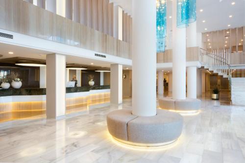 a lobby of a building with columns and a staircase at Grupotel Gran Vista & Spa in Can Picafort
