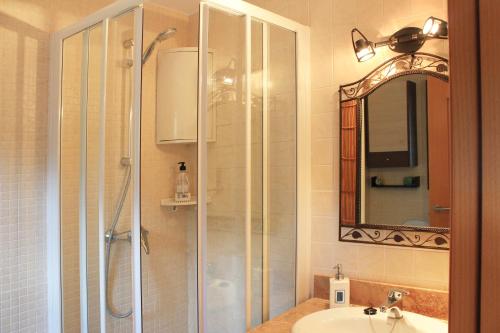 ein Bad mit einer Dusche, einem Waschbecken und einem Spiegel in der Unterkunft Holiday Tossa Apartment in Tossa de Mar