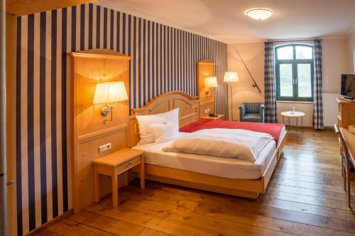 ein Schlafzimmer mit einem Bett und einer gestreiften Wand in der Unterkunft Gasthaus Luthemuhle in Nettetal