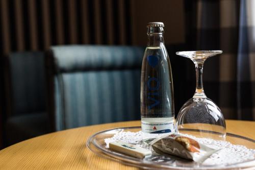 a bottle of alcohol sitting on a table next to a wine glass at Gasthaus Luthemuhle in Nettetal