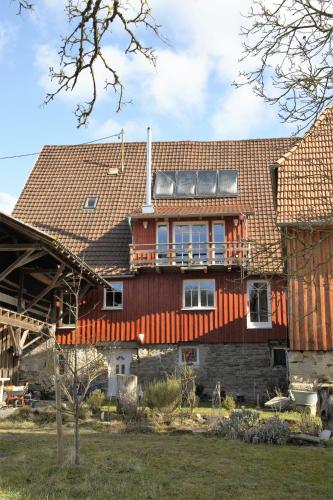 a large red house with a roof on top of it at Gemütliche Gästezimmer in einem neu sanierten Fachwerkhaus in Sachsenheim
