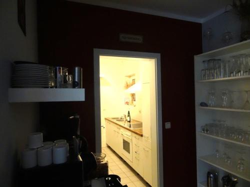 eine Küche mit einem Waschbecken und einer Tür zum Tresen in der Unterkunft Ferienhaus Loissin in Loissin