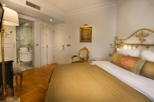 Un dormitorio con una cama grande y un baño. en Valide Sultan Konagi, en Estambul