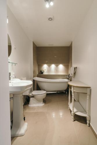 a bathroom with a tub and a toilet and a sink at Merchants House Hotel in Tallinn
