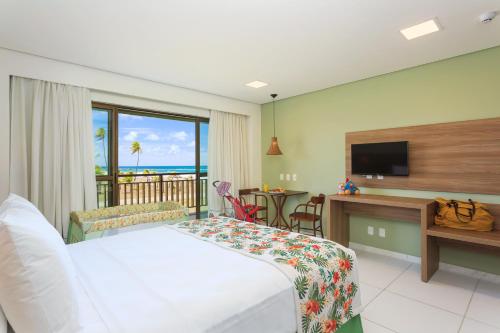 a hotel room with a bed and a television at Vivá Porto de Galinhas Resort in Porto De Galinhas