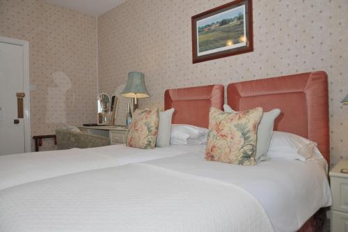 a bedroom with a large white bed with pillows at The Inglenook Hotel in Bognor Regis