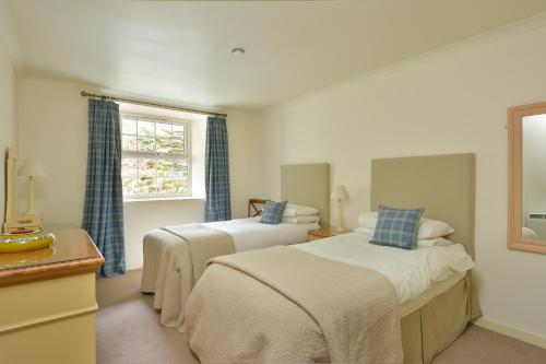 a bedroom with two beds and a window at Melfort Village in Oban
