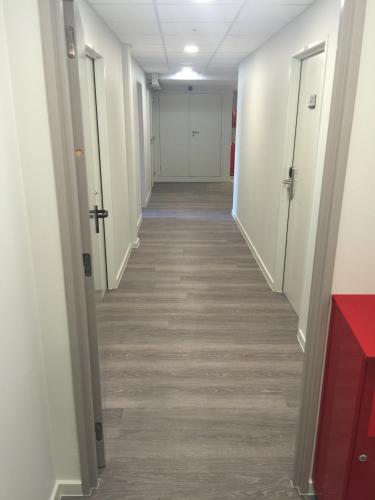 a hallway of an office building with white walls and wood floors at Auberge des 3 Fontaines in Brussels